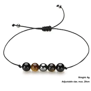 Macro view of handmade woven bracelet featuring tiger eye and hematite stone beads