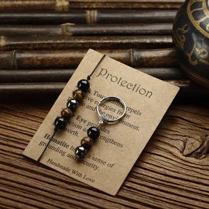 Handmade tiger eye and hematite beaded jewelry set on a protection card background.