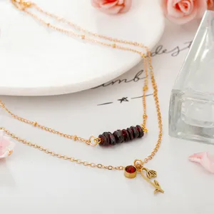 Detailed macro view of multi-layered garnet gravel necklace with elegant tulip pendant