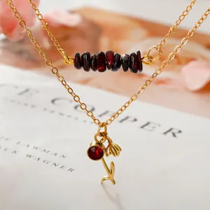 Beautiful close-up of double-layer garnet gravel necklace with gold flower pendant.