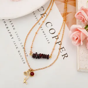 Detailed view of gold multi-layer necklace with garnet chips and snow lotus pendant