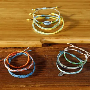 Detailansicht böhmischer geflochtener Wachsfadenarmbänder mit Muschel- und Blattanhängern