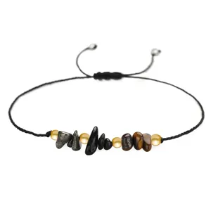 Handgewebtes Armband aus Hämatit und Tigerauge mit Kupferperlen auf schwarzer Schnur.