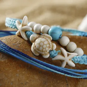 Nahaufnahme von böhmischen gewachsten Kordelarmbändern mit Schildkröten- und Seestern-Anhängern.