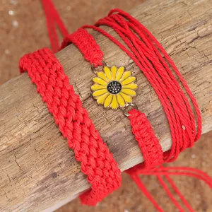 Vista detallada del conjunto de pulseras bohemias trenzadas rojas con dije de margarita