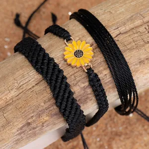 Primer plano del set de pulseras bohemias de hilo encerado negro con dije de girasol