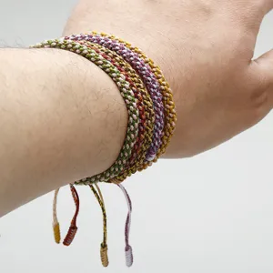 Close-up showing detail of handmade woven Tibetan style cotton cord bracelets on wrist