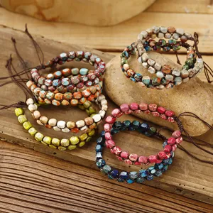 Détail de bracelets double couche en pierre d'empereur tissés main sur une pierre.