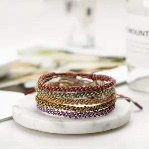 Detailed view of colorful hand-woven braided friendship bracelets on a marble coaster