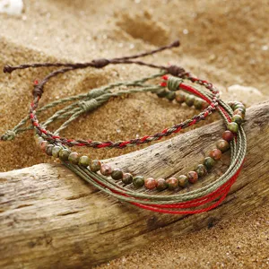 Macro view of handmade braided wax thread bracelets with African turquoise stone beads