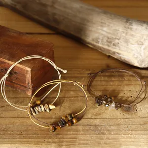 Handgefertigte verstellbare Armbänder mit Natursteinchips auf rustikalem Holzgrund