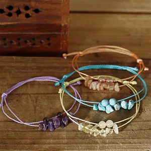 Detailansicht von vier handgefertigten Armbändern mit Natursteinsplittern und Perlen