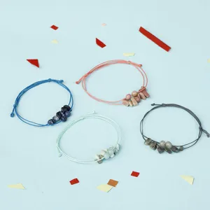Detailansicht von vier handgefertigten Kordelarmbändern mit Natursteinen und Perlen