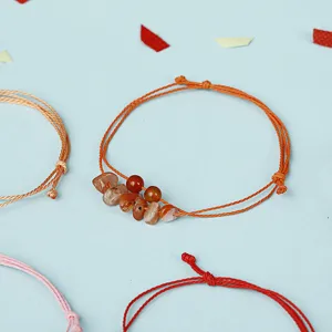 Detailansicht eines orangefarbenen handgemachten Schnurarmbands mit Karneol-Natursteinen