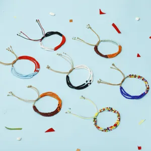 Primer plano de pulseras bohemias de cuentas de semillas de colores sobre fondo azul.