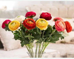 Vue détaillée de renoncules artificielles colorées dans un vase, idéales pour la décoration.