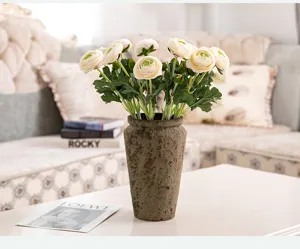 Bouquet de fleurs de renoncules artificielles avec vase vintage pour la déco de salon.