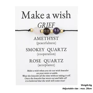 Close-up of a wish bracelet on a display card featuring Amethyst and Quartz beads