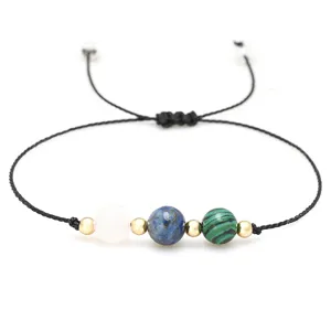 Dettaglio delle perle in quarzo rosa, lapislazzuli e malachite su bracciale a cordino.