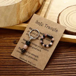 Handgefertigtes Set aus Natursteinring und Schlüsselanhänger auf rustikaler Kraftkarte.