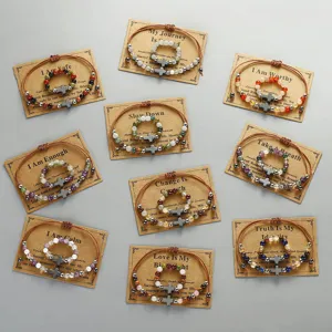 Handgefertigtes Edelsteinperlen-Armband und Ring-Set mit Kreuzanhängern auf Karten