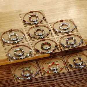 Detailansicht verschiedener Perlenarmband- und Ringsets aus Stein mit Kreuzanhängern