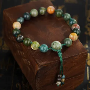 Detailopname van een natuurlijke Indiase agaat kralenarmband op een houten displayblok.