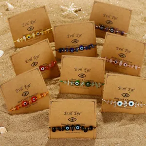 Handgefertigte Evil Eye Armbänder mit bunten Kristallchips und Glasperlen auf Sand