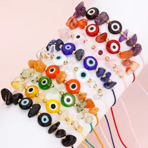 Nahaufnahme handgefertigter Evil-Eye-Armbänder mit Natursteinchips und Kupferperlen.