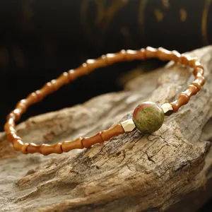 Macro view of Chinese style bamboo joint olive pit bracelet with natural green stone
