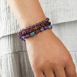 Detalle de pulsera tejida a mano multicapa con cuentas de amatista y piedra emperador