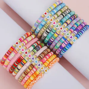 Detail von farbenfrohen Boho-Armbändern aus Polymer-Heishi-Perlen mit Herzanhängern