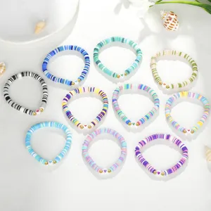 Detailansicht von zehn bunten handgemachten Boho-Polymer-Ton-Armbändern mit Herzanhänger
