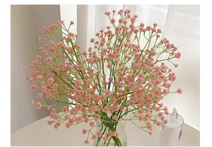 Primer plano de ramo de flores artificiales rosa paniculata en florero de vidrio decoración boda