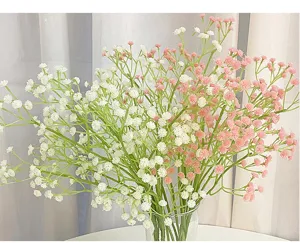 Detalle de ramo de paniculata artificial, flores blancas y rosas en florero de cristal.