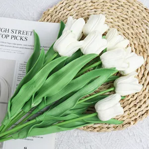 Close up of artificial white tulips bouquet with green leaves for home decoration and photography.