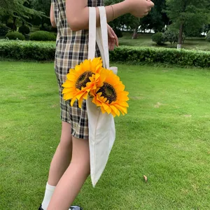 Bouquet de tournesols artificiels dans un sac en toile blanc pour la décoration et fêtes.