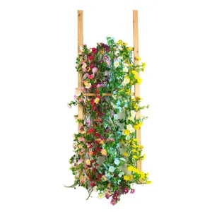 Kunstmatige madeliefjes bloemenguirlande op houten ladder voor wanddecoratie in huis