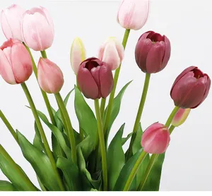 Close-up detail of artificial tulip flowers bouquet with soft PU petals and green leaves.