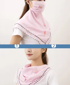 Detail view of chiffon sun protection face mask with delicate floral embroidery and ear loops.