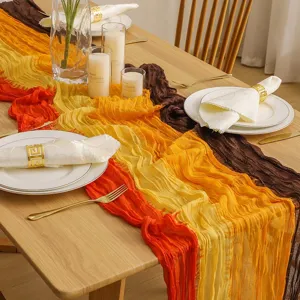 Detalle de camino de mesa de gasa boho con colores degradados tie-dye para bodas.