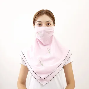 Detailed view of the pink chiffon sun protection face mask with delicate floral embroidery.