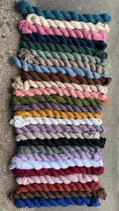 Vue detaillee montrant diverses couleurs de rouleaux de tissu pour chemin de table en gaze.