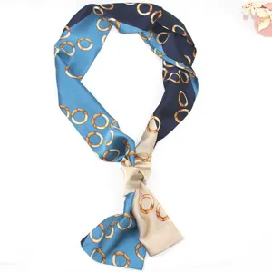 Detail of narrow silk twilly scarf with blue chain print for women handbag ribbon handle.