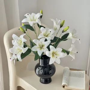 Artificial white lily flowers bouquet in black ceramic vase for modern home decor styling.