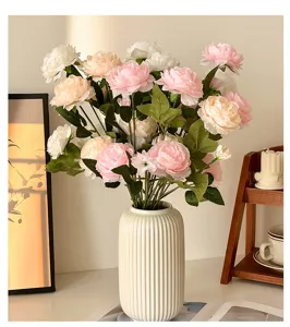Detailed view of artificial Persian buttercup bouquet in white ceramic vase, home decor setup.