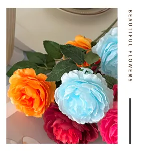 Artificial flower bouquet detail shot, colorful silk peonies and green leaves for home decoration.