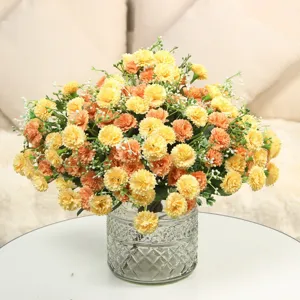 Gros plan détail de faux œillets colorés et lilas dans un vase en verre texturé clair.
