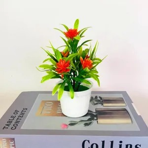 Artificial lotus potted plant with green leaves in a white pot for home and desk decoration.