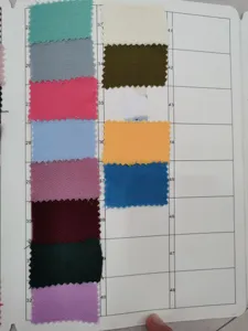 Fabric color swatch card showing various shades and textures for textile selection.